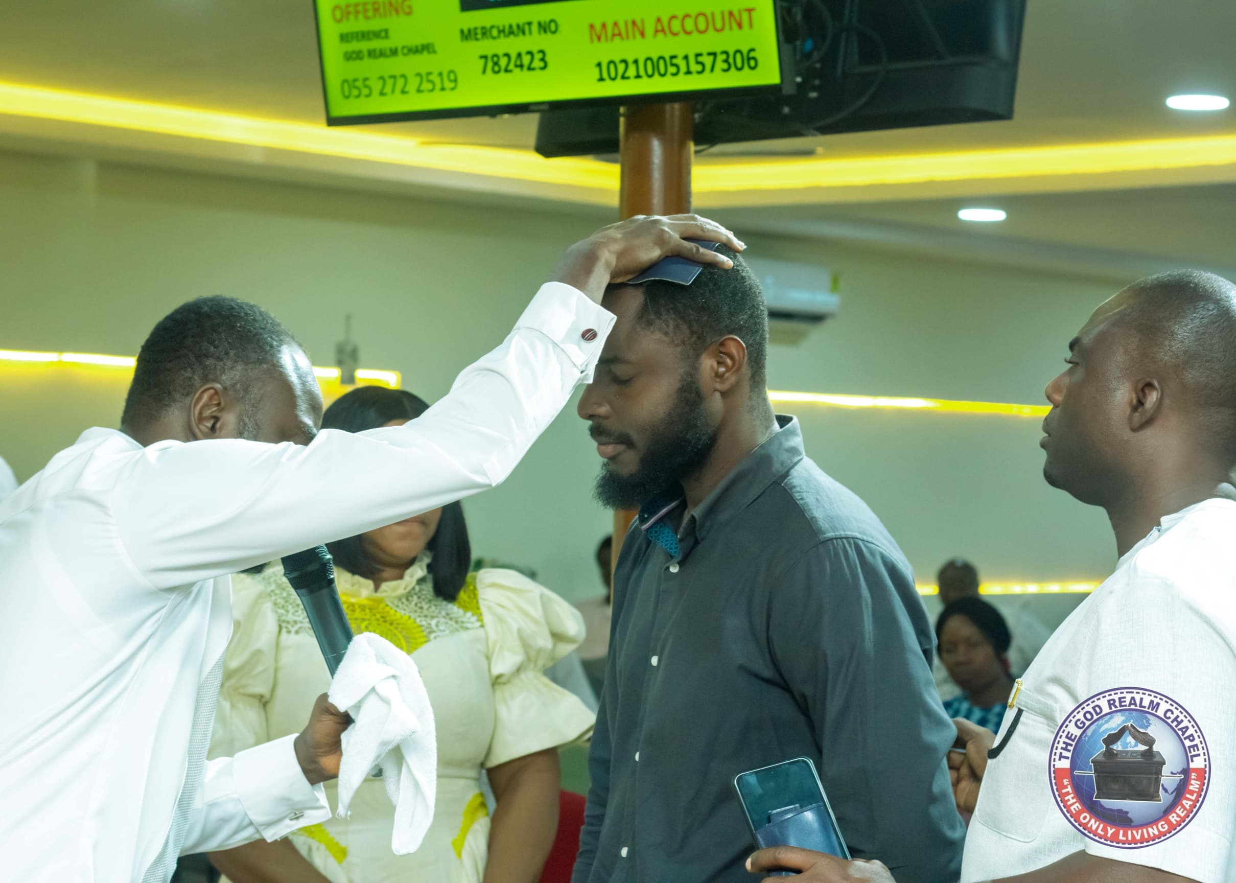 Pastor laying hands on a young man in prayer