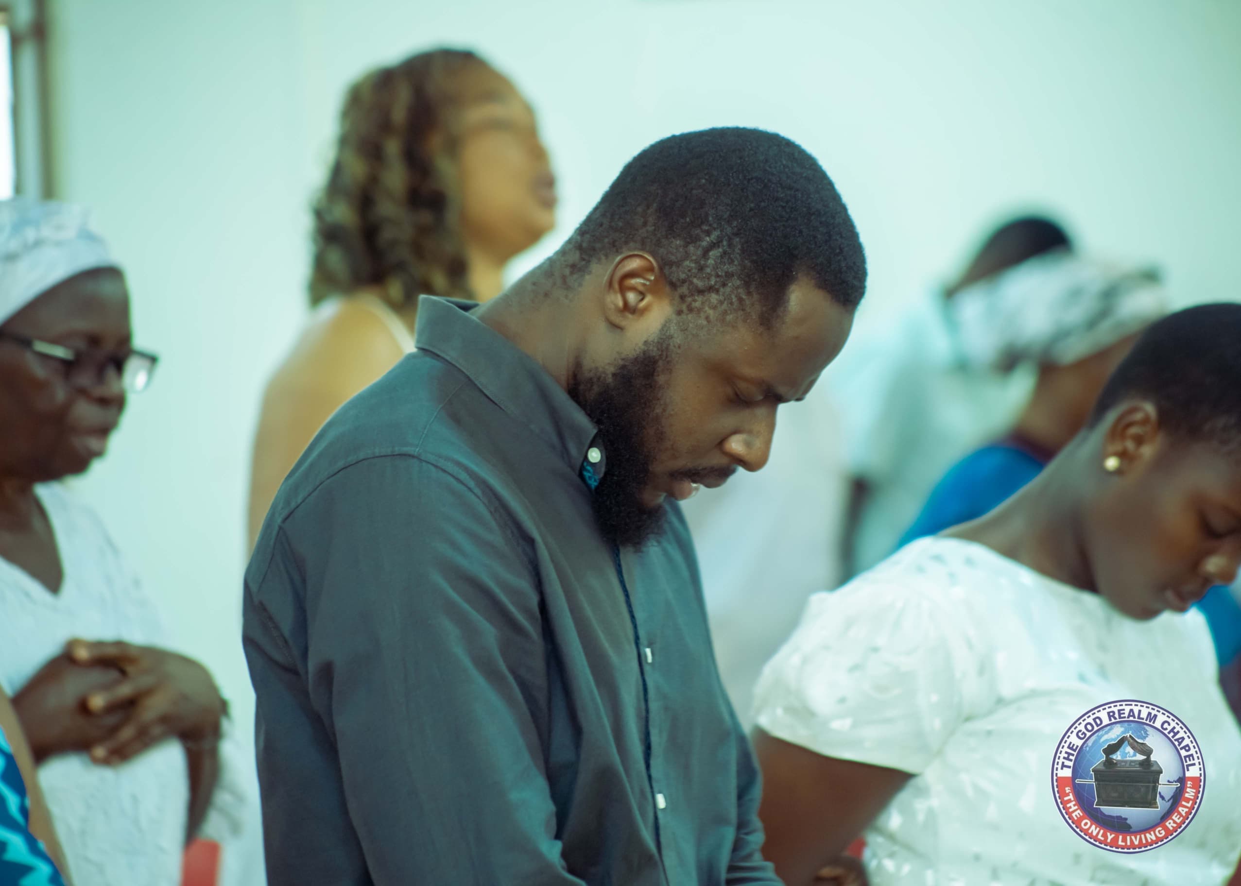 Young man bowed in prayer during a church service