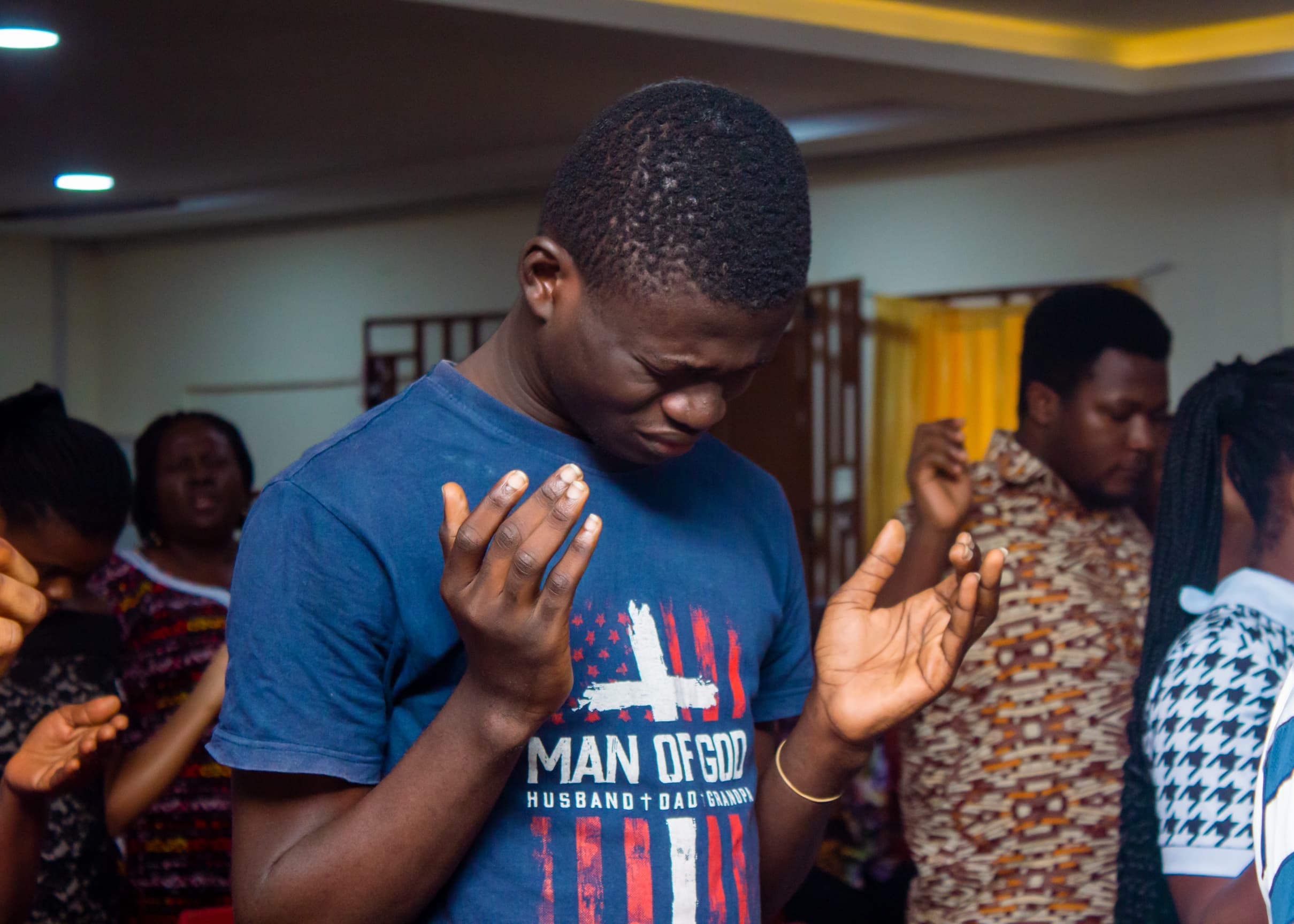 Man praying with raised hands during a church gathering