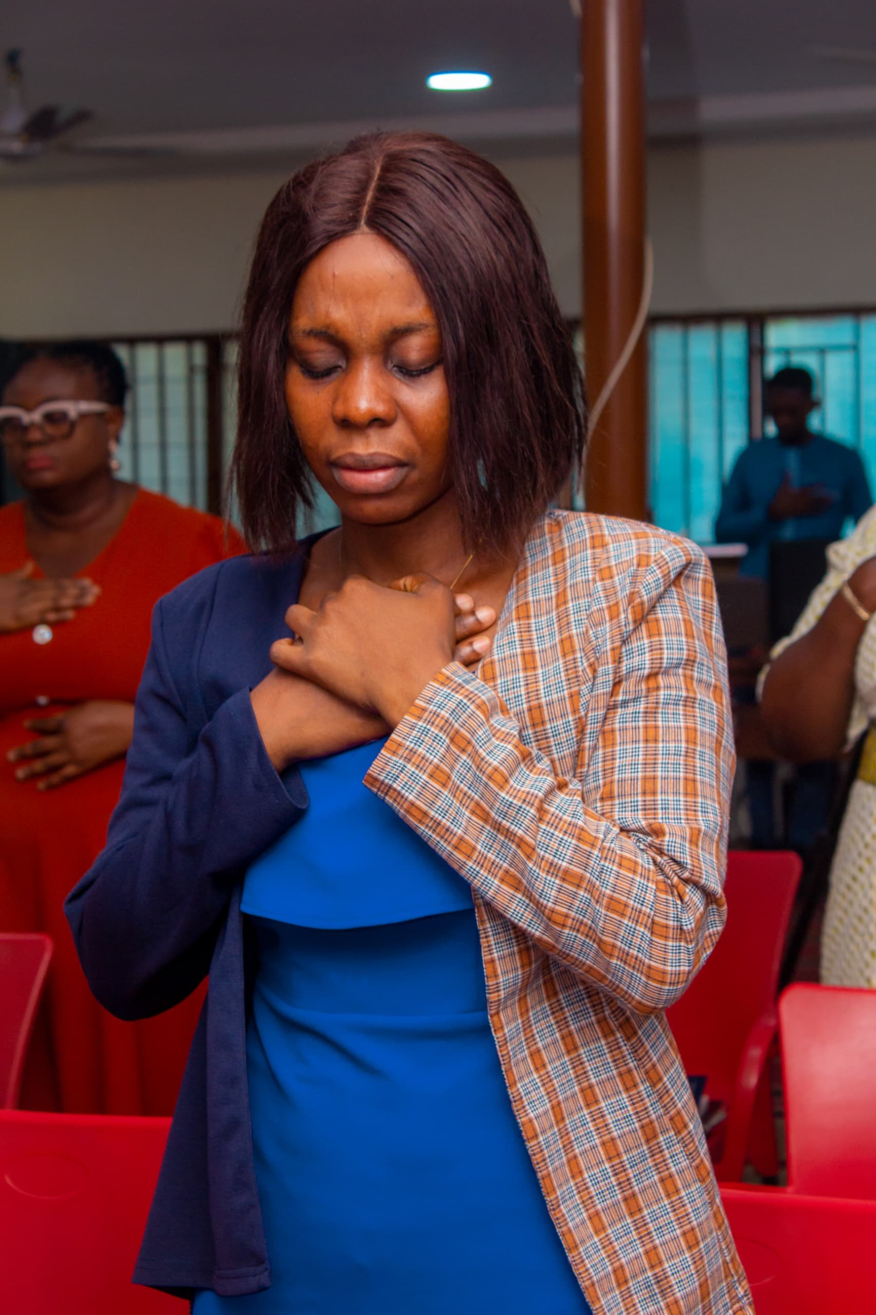 Young woman in devotional prayer at a church gathering