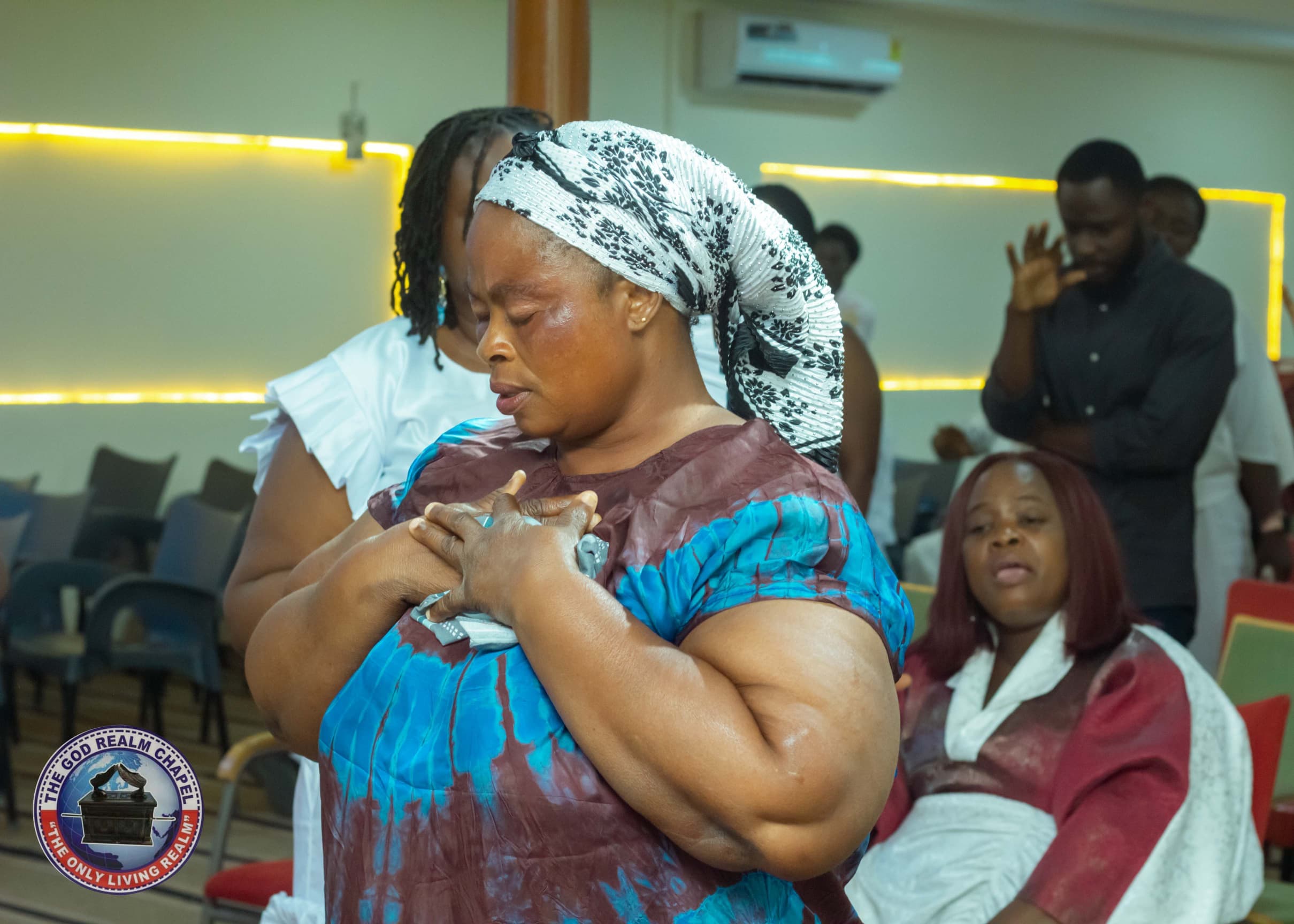 Woman praying with hands over her heart during worship