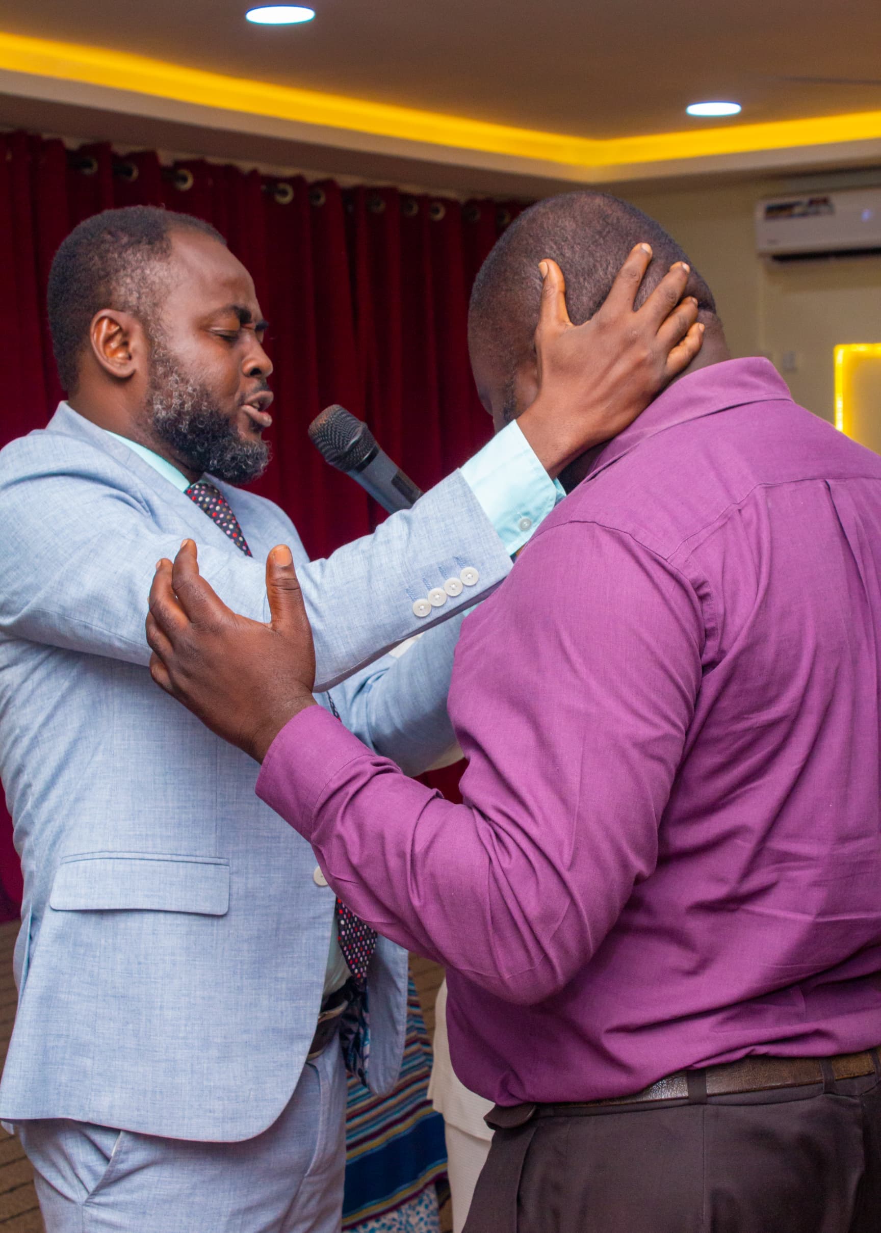 Pastor praying for a member during ministration