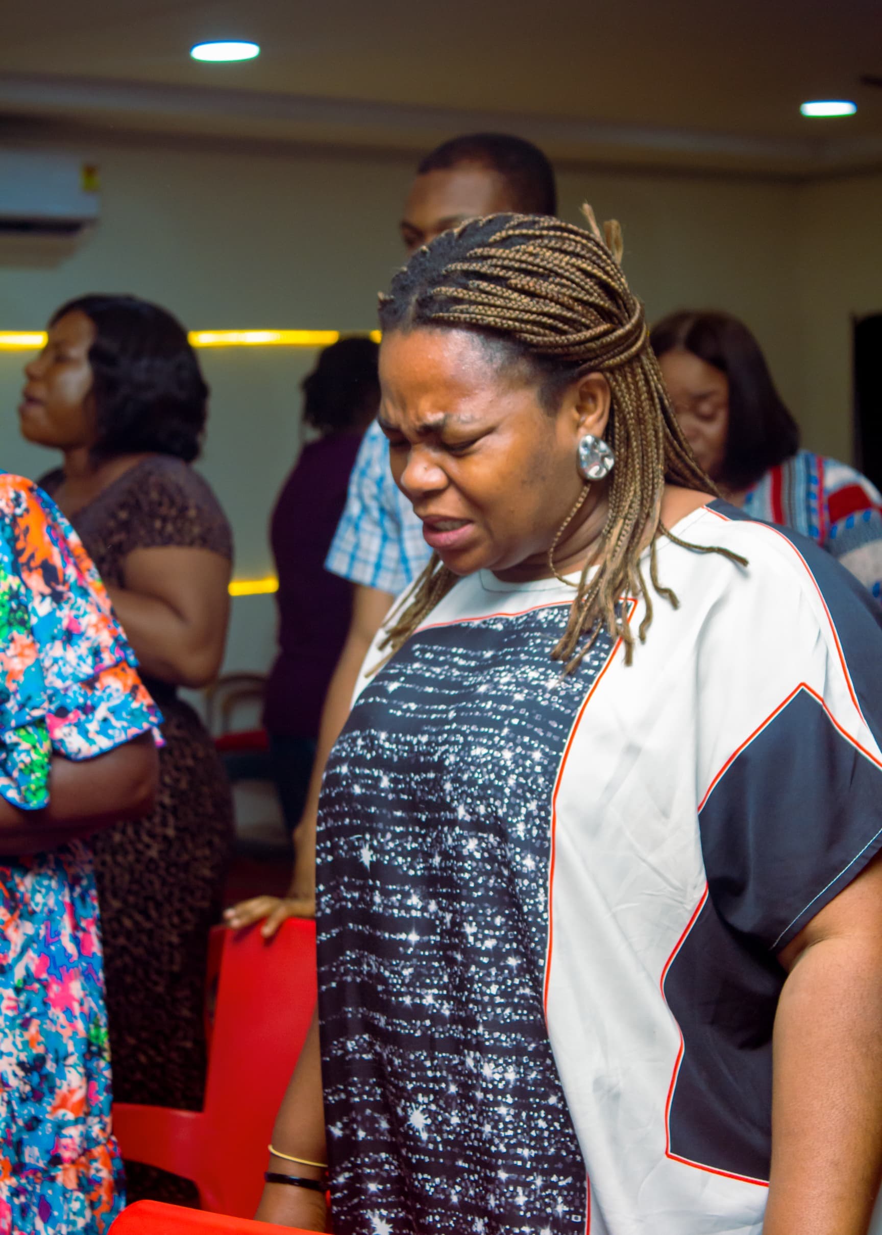 Woman in intense prayer during a church gathering