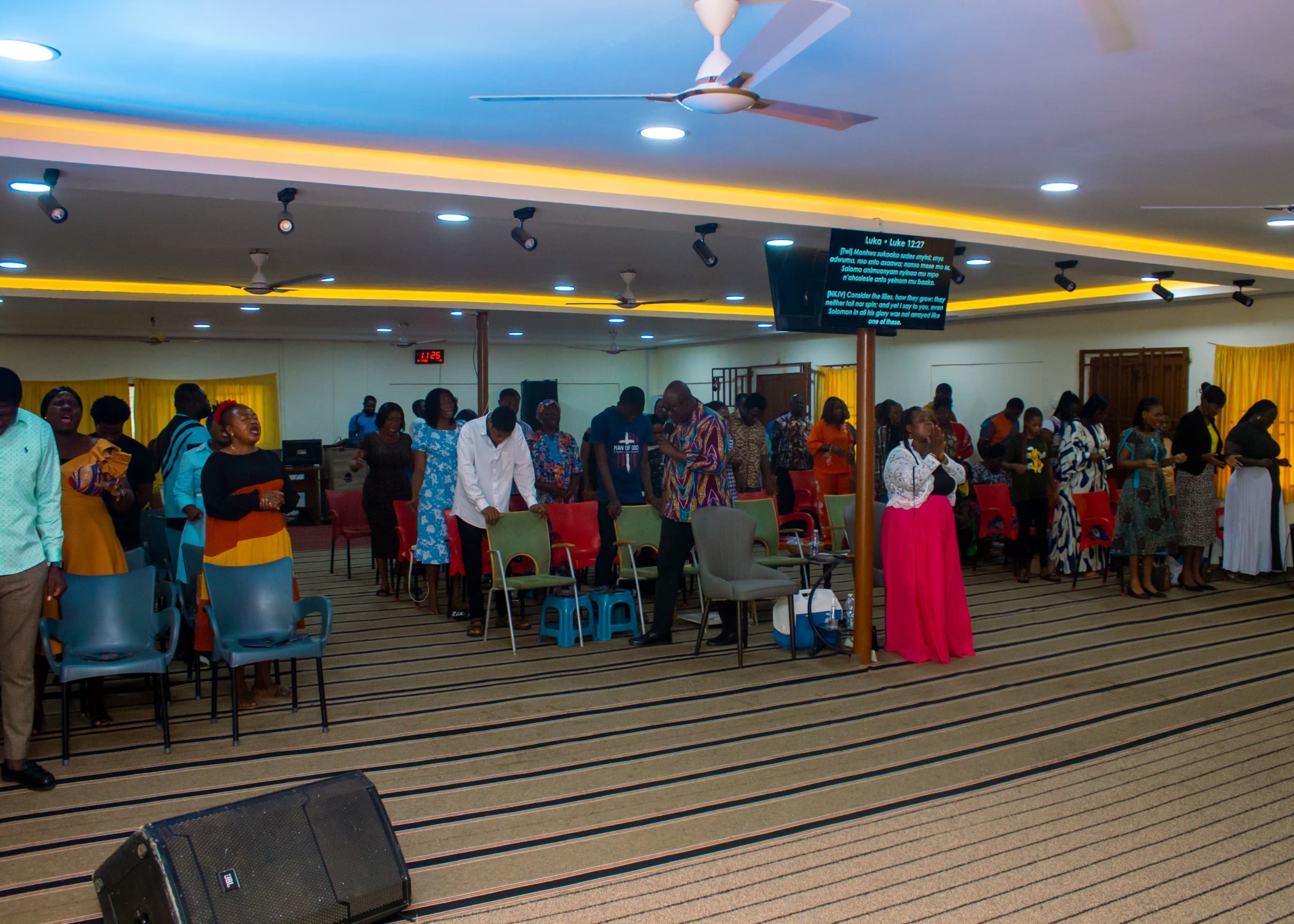 Full congregation standing in prayer at The God Realm Chapel