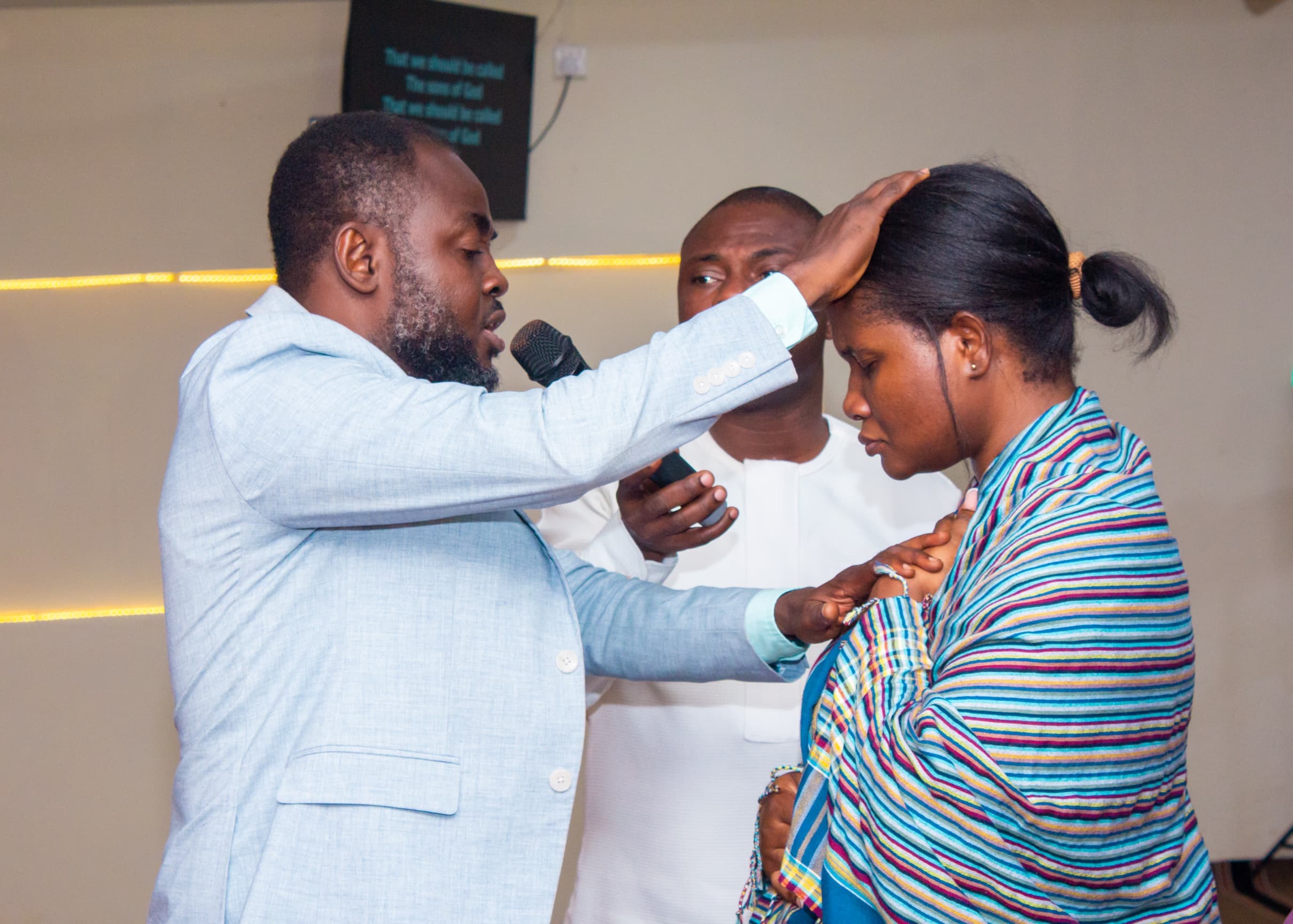 Pastor laying hands in prayer during ministration